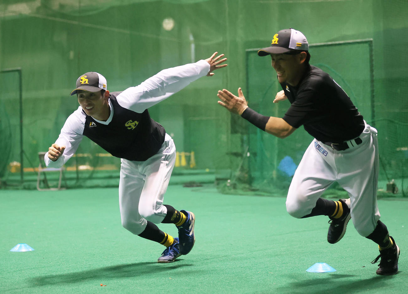 ウォーミングアップを行うソフトバンク周東、右は牧原大（撮影・冨田成美）