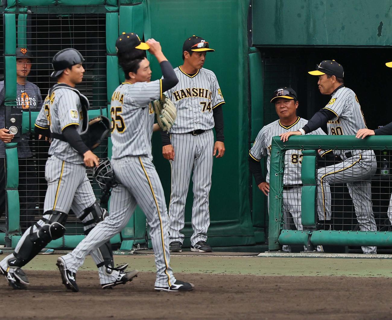 巨人対阪神　7回、2失点しベンチへ引き揚げる湯浅（左から2人目）とコーチ陣と話す岡田監督（右）（撮影・上田博志）
