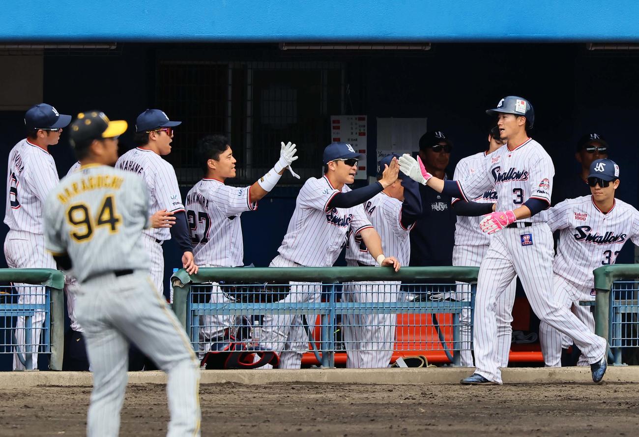 ヤクルト対阪神　1回裏ヤクルト無死一、三塁、サンタナの併殺打の間に生還した西川はナインとハイタッチをする（撮影・上田博志）