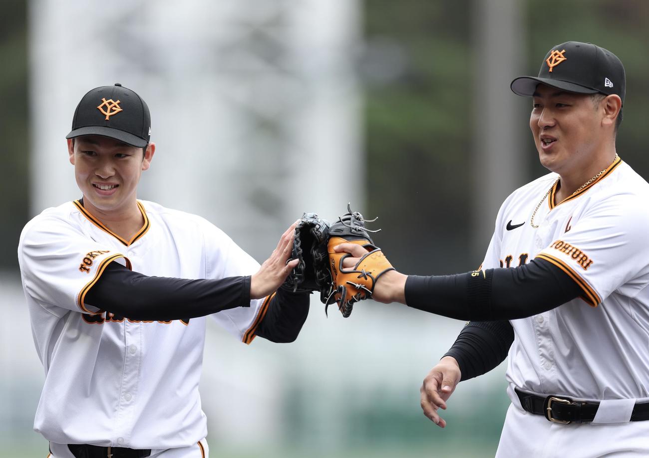 巨人対ヤクルト　1回表を抑え、タッチを交わす山崎伊（左）と岡本和（撮影・河田真司）