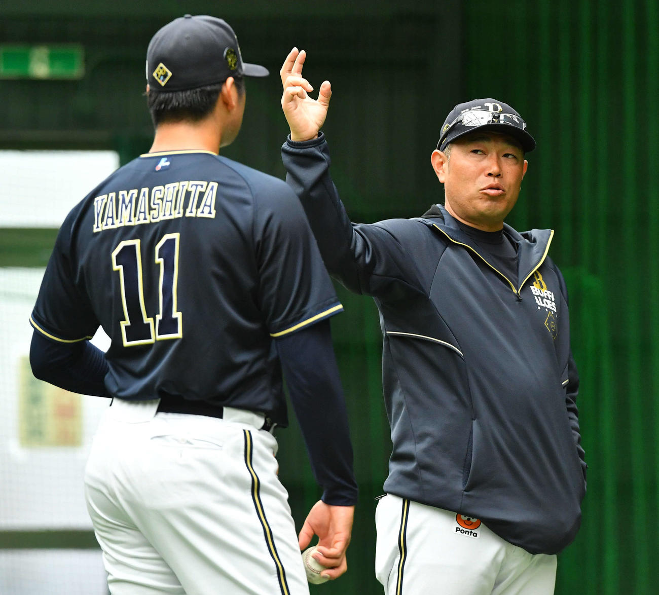 ブルペンでの投球を終えた山下（左）と話すオリックス平井コーチ（撮影・岩下翔太）