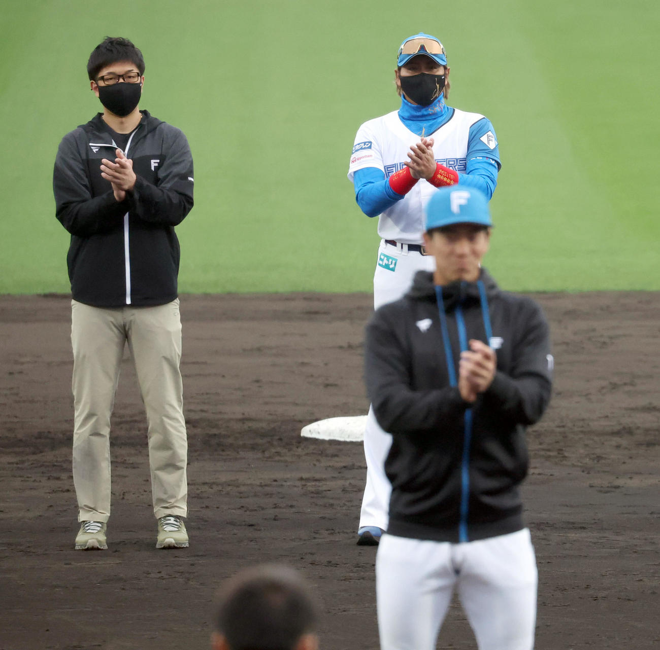 春季キャンプを終え日本ハム松本剛（手前）の掛け声で手締めをする新庄監督（右）（撮影・佐藤翔太）
