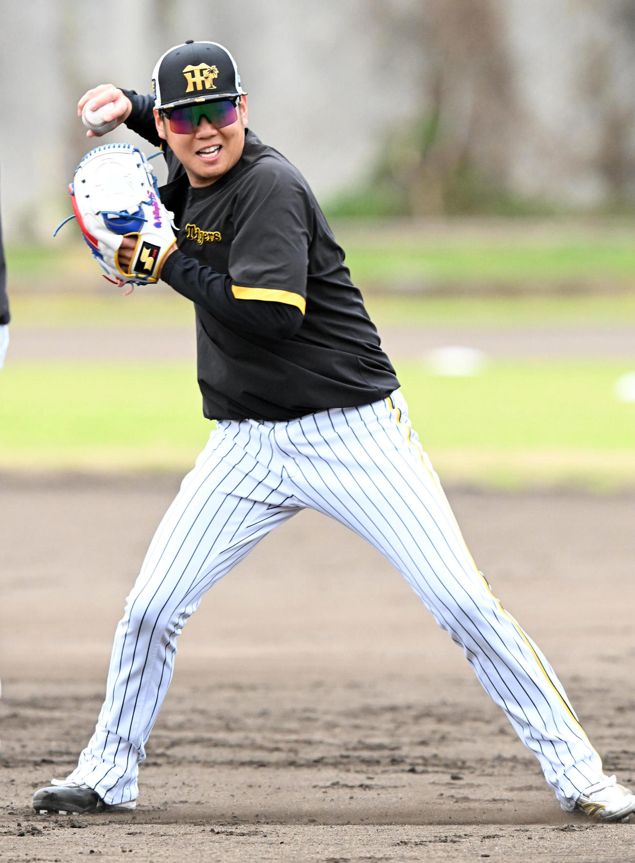 笑顔で投内連係を行う阪神西勇（撮影・前岡正明）