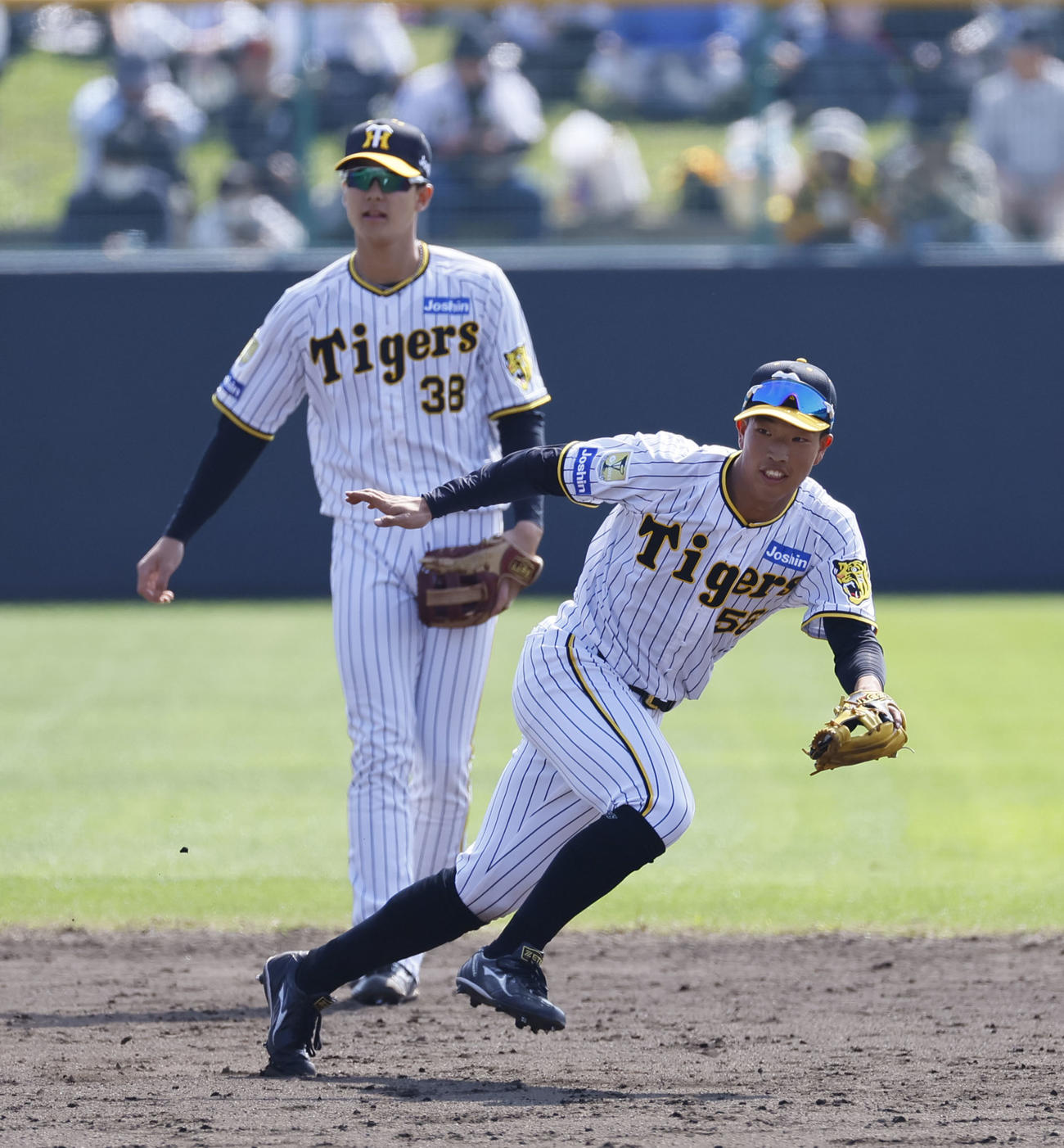 シートノックで遊撃を守る百崎蒼生（右）＝2024年2月11日