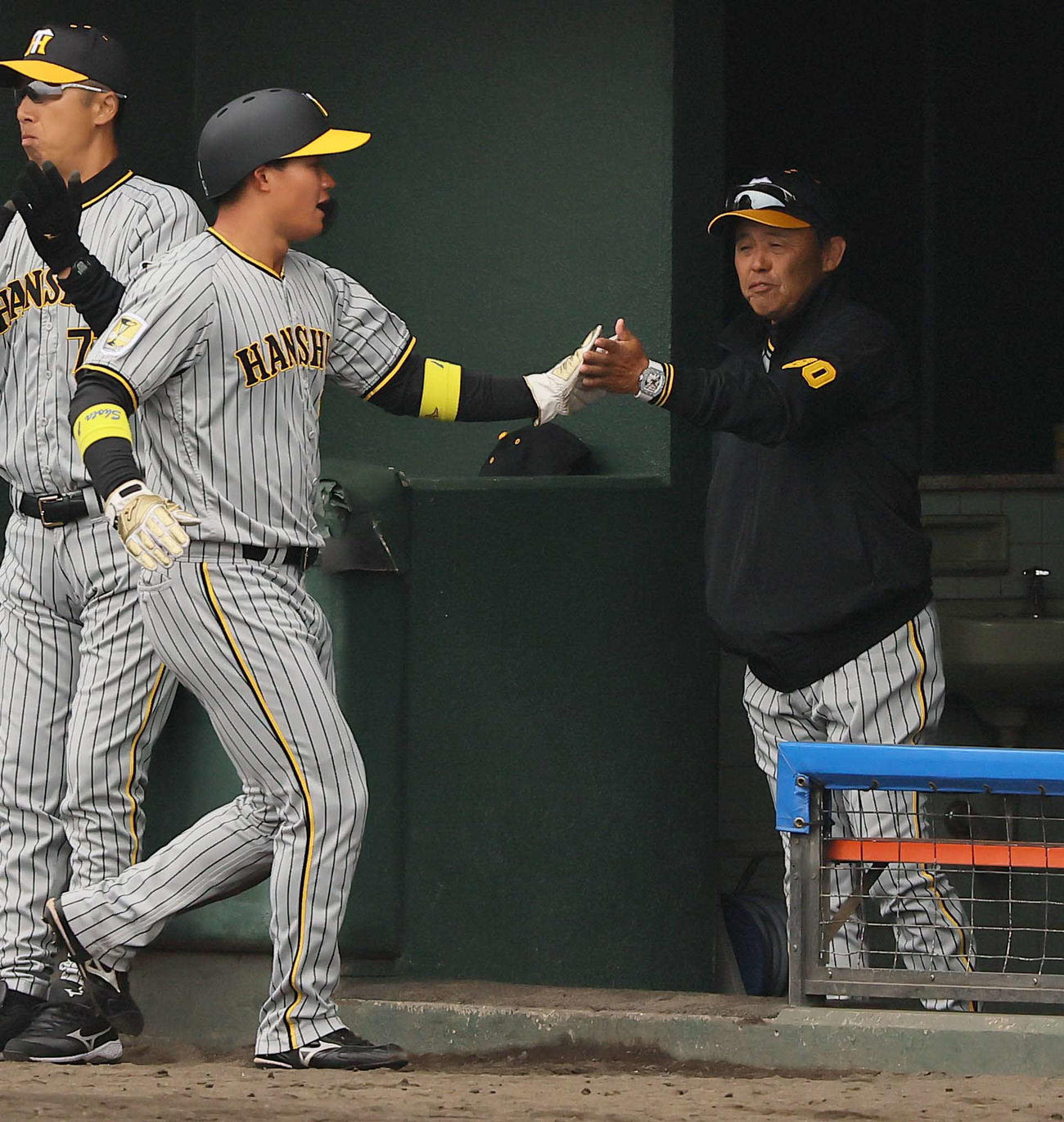 中日対阪神　2回表阪神2死一、二塁、坂本の左前先制適時打で生還した森下（左）をハイタッチで出迎える岡田監督（撮影・上田博志）