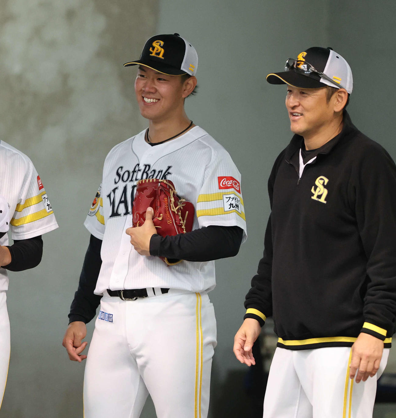 22日、ブルペンで笑顔を見せる岩井。右は倉野コーチ