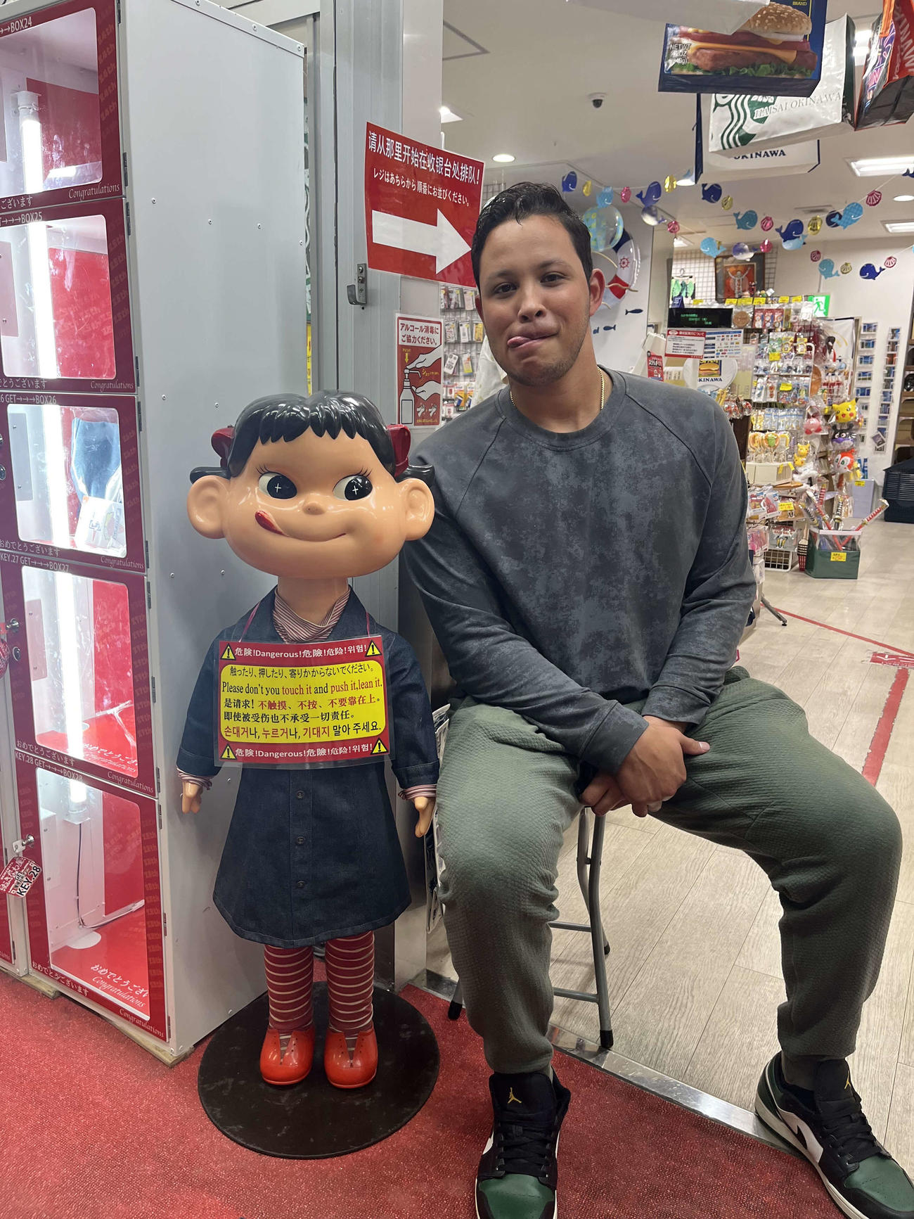 国際通りの店頭に飾られた「ペコちゃん」とツーショット撮影するヤクルトのヤフーレ（本人提供）