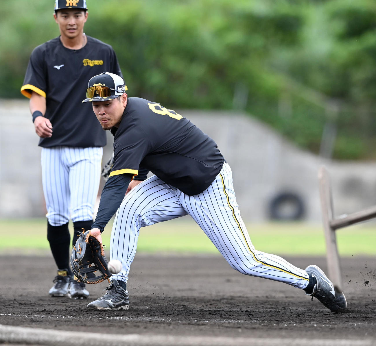 特守で軽快な動きを見せる阪神佐藤輝。後方は熊谷（撮影・前岡正明）
