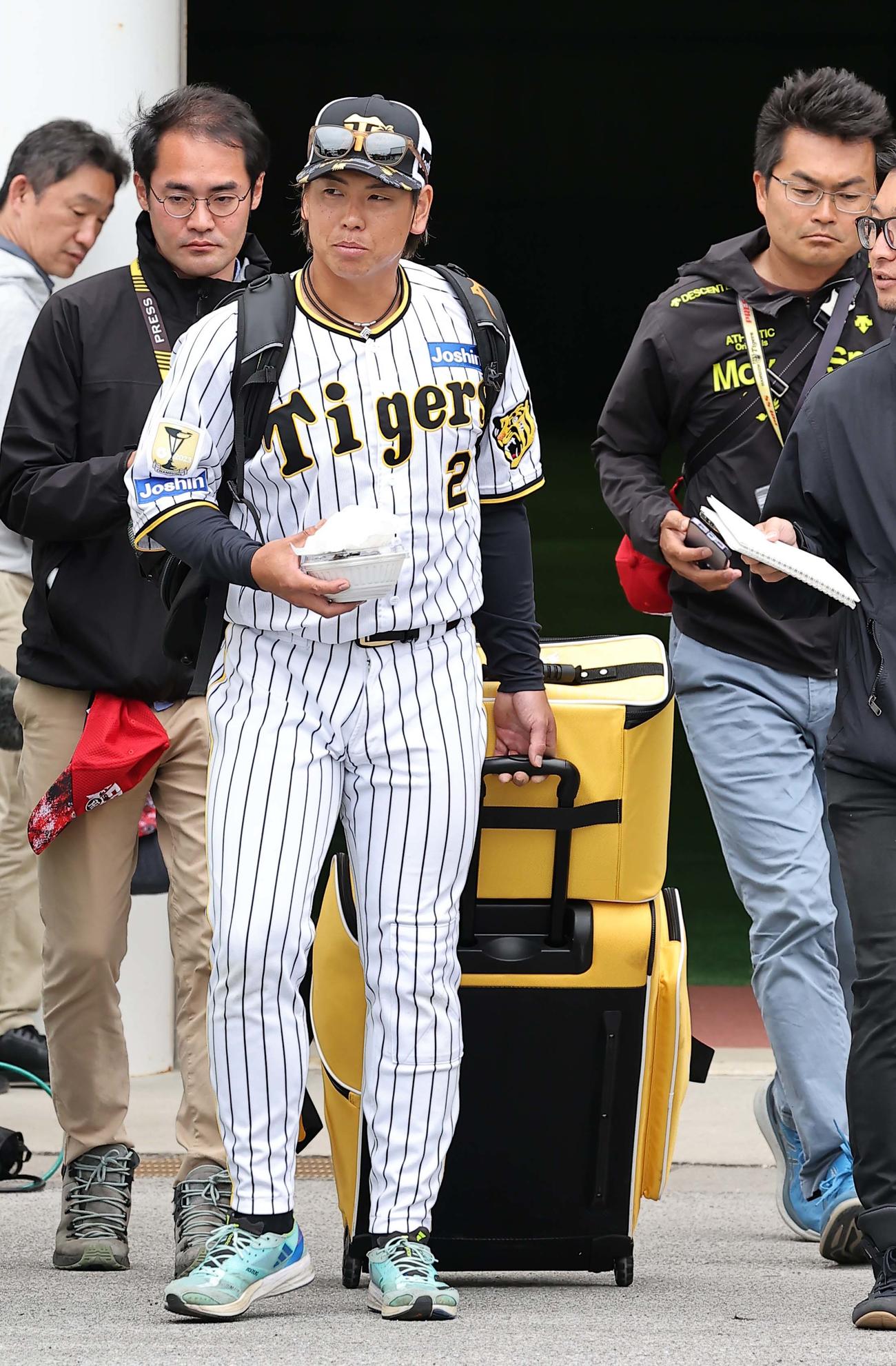 春季キャンプを終えた梅野は荷物を引いてバスに向かう（撮影・上田博志）