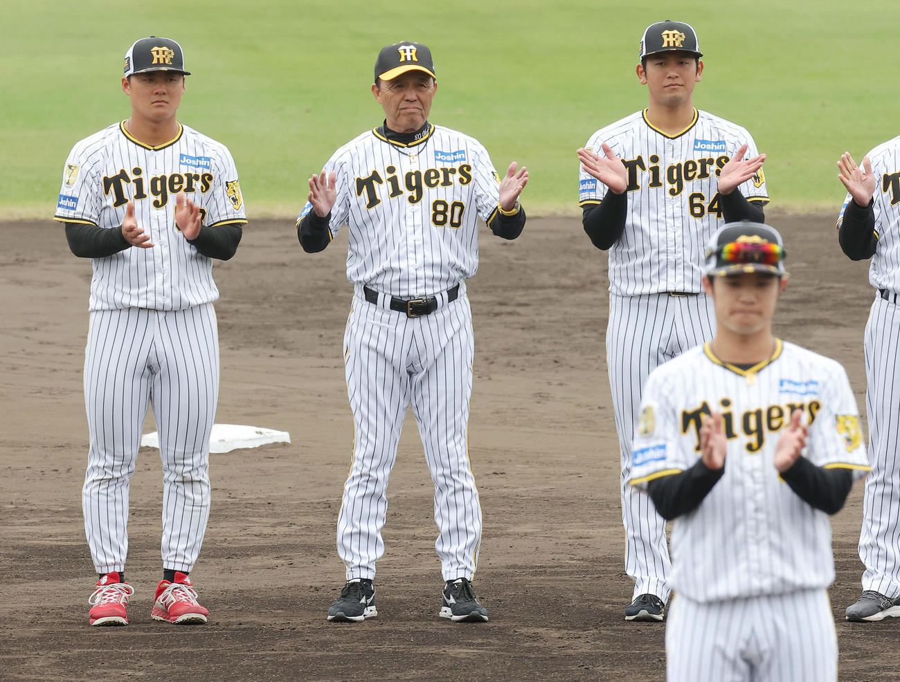 一本締めで宜野座での春季キャンプを打ち上げる、左から阪神前川、岡田監督、岡留。手前は中野（撮影・前田充）