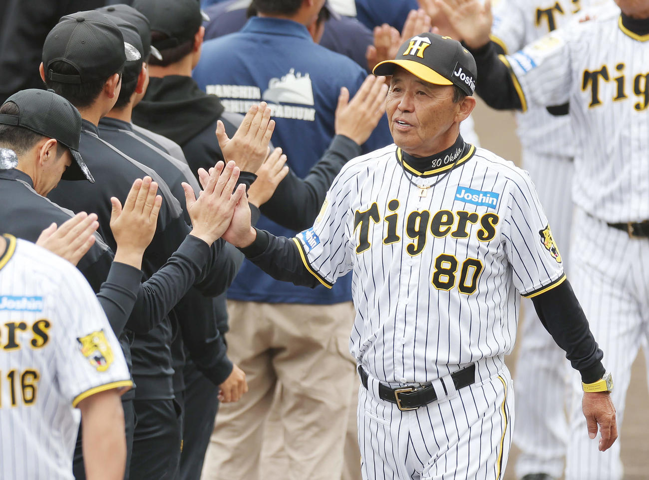 春季キャンプを打ち上げ、スタッフらとハイタッチを交わす阪神岡田監督（撮影・前田充）