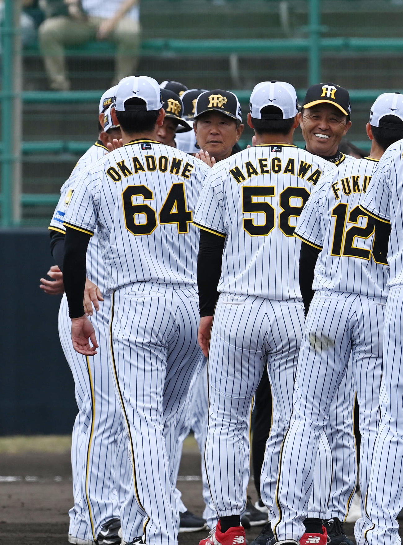 宜野座春季キャンプを打ち上げ前川（中央）と笑顔でタッチする岡田監督（右）。左は岡留（撮影・前岡正明）