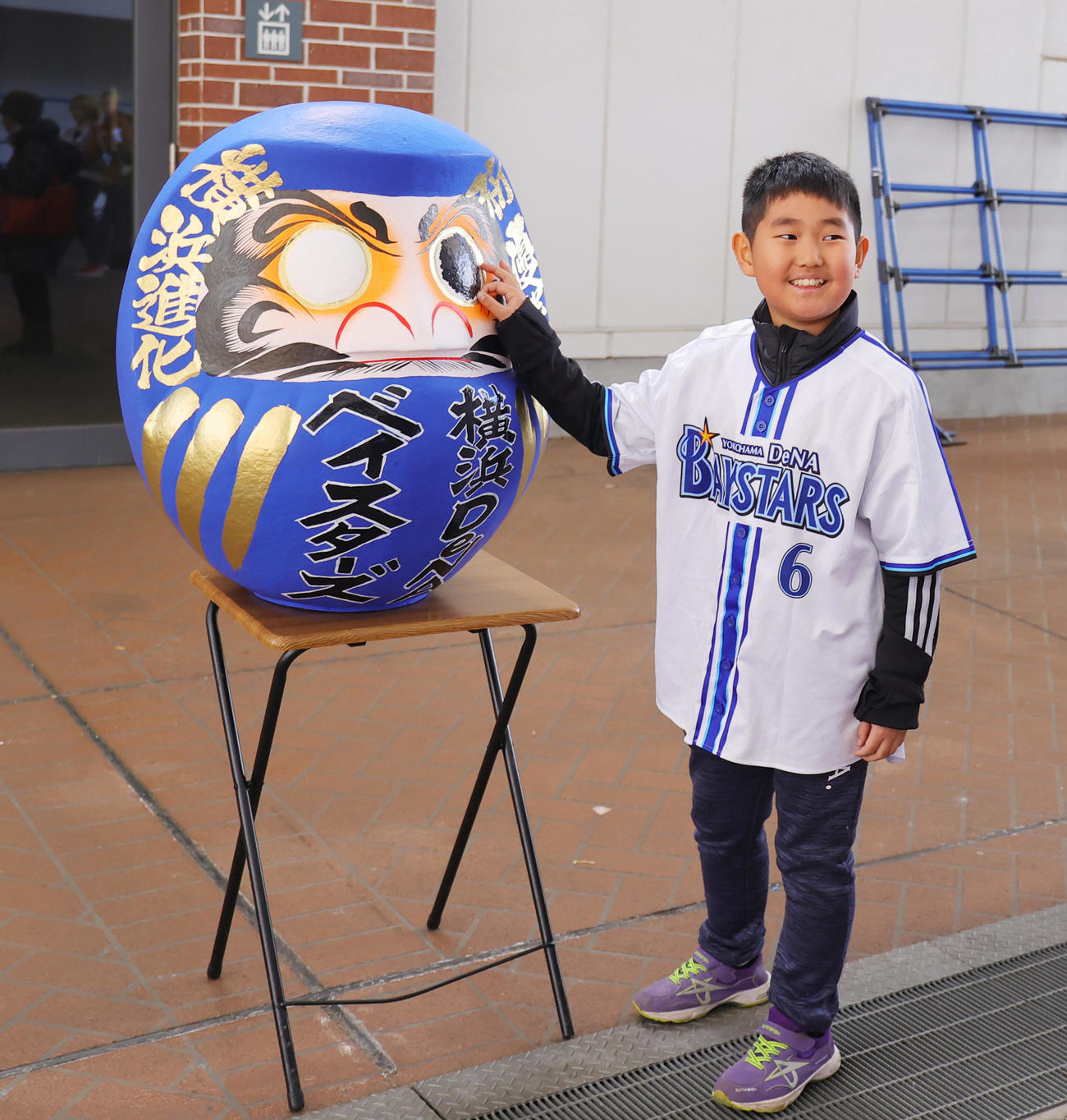 DeNAの必勝祈願で、だるまの目にシールをはる少年ファン（撮影・野上伸悟）