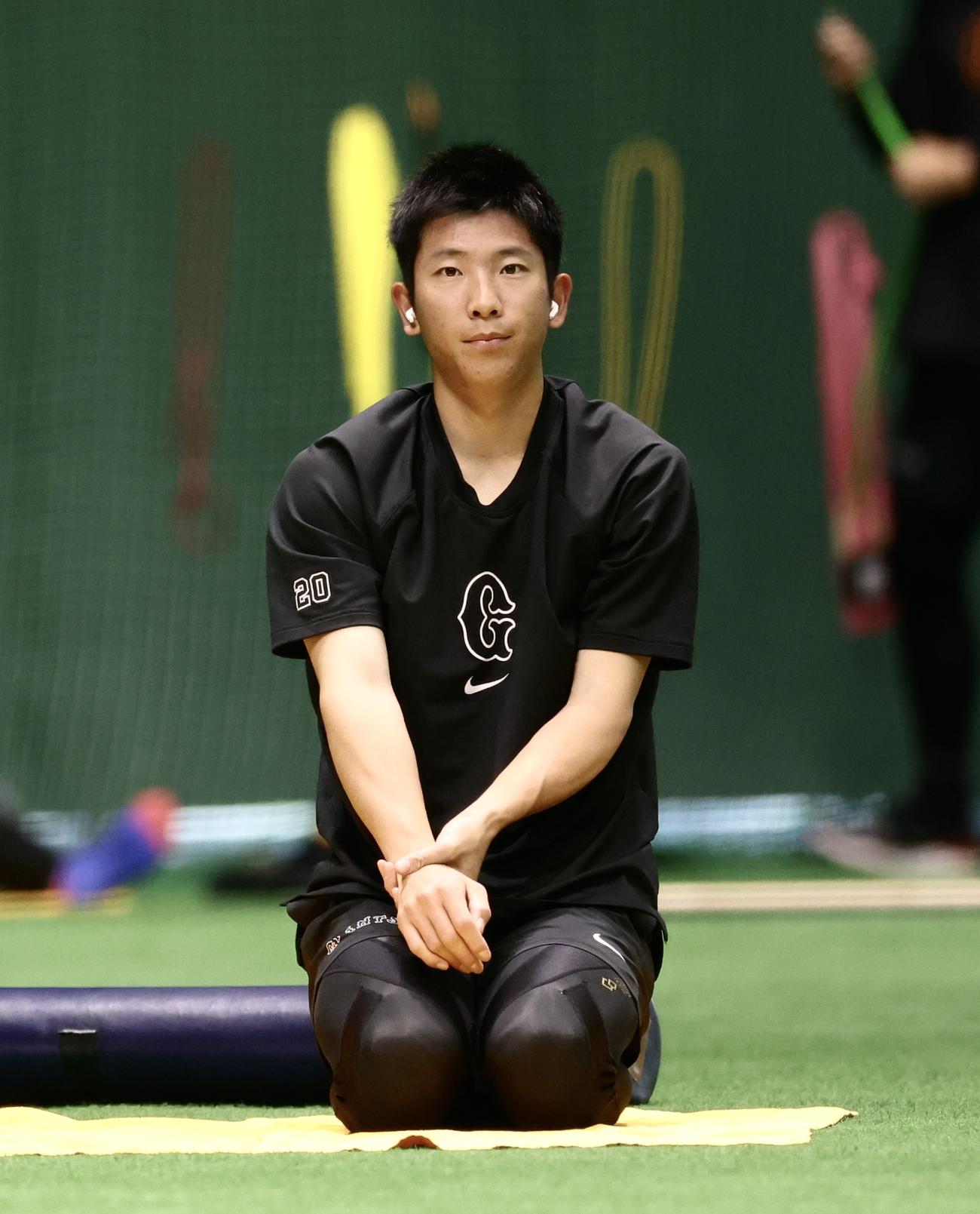 室内でストレッチする巨人戸郷（撮影・河田真司）