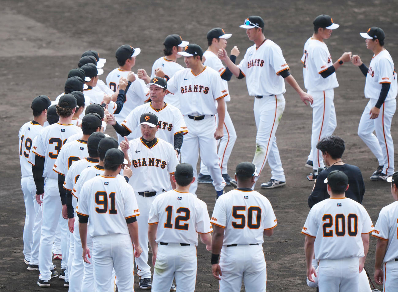 キャンプを打ち上げ、選手たちとタッチを交わす巨人阿部監督ら（撮影・江口和貴）