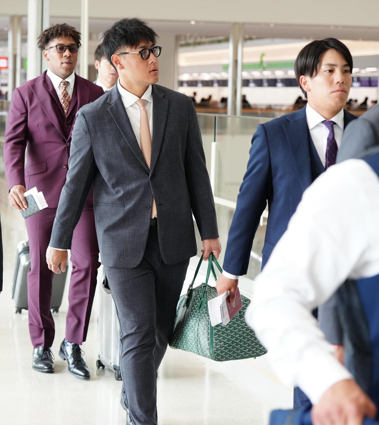 台湾遠征に向け、沖縄・那覇空港の保安検査場に向かう岡本和（手前左）ら巨人の選手たち。同右は門脇、後方左はオコエ（撮影・江口和貴）