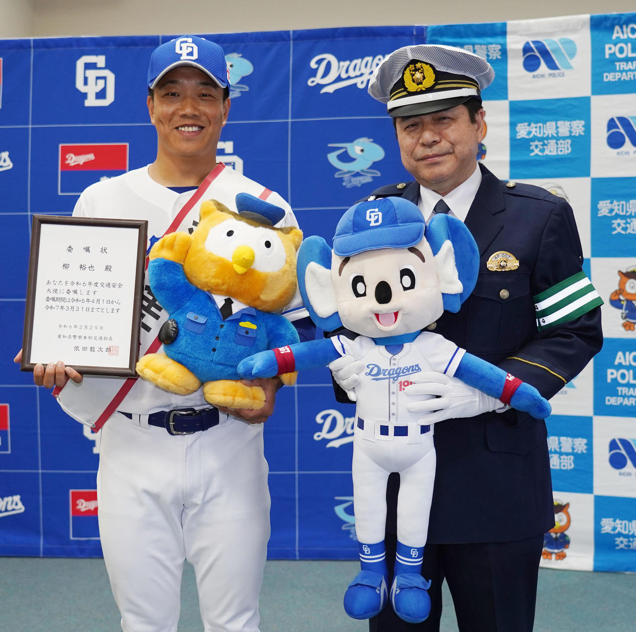 依田龍次郎愛知県警察本部交通部長より委嘱状を受け取りマスコットを交換し記念撮影に納まる柳（左）（撮影・森本幸一）