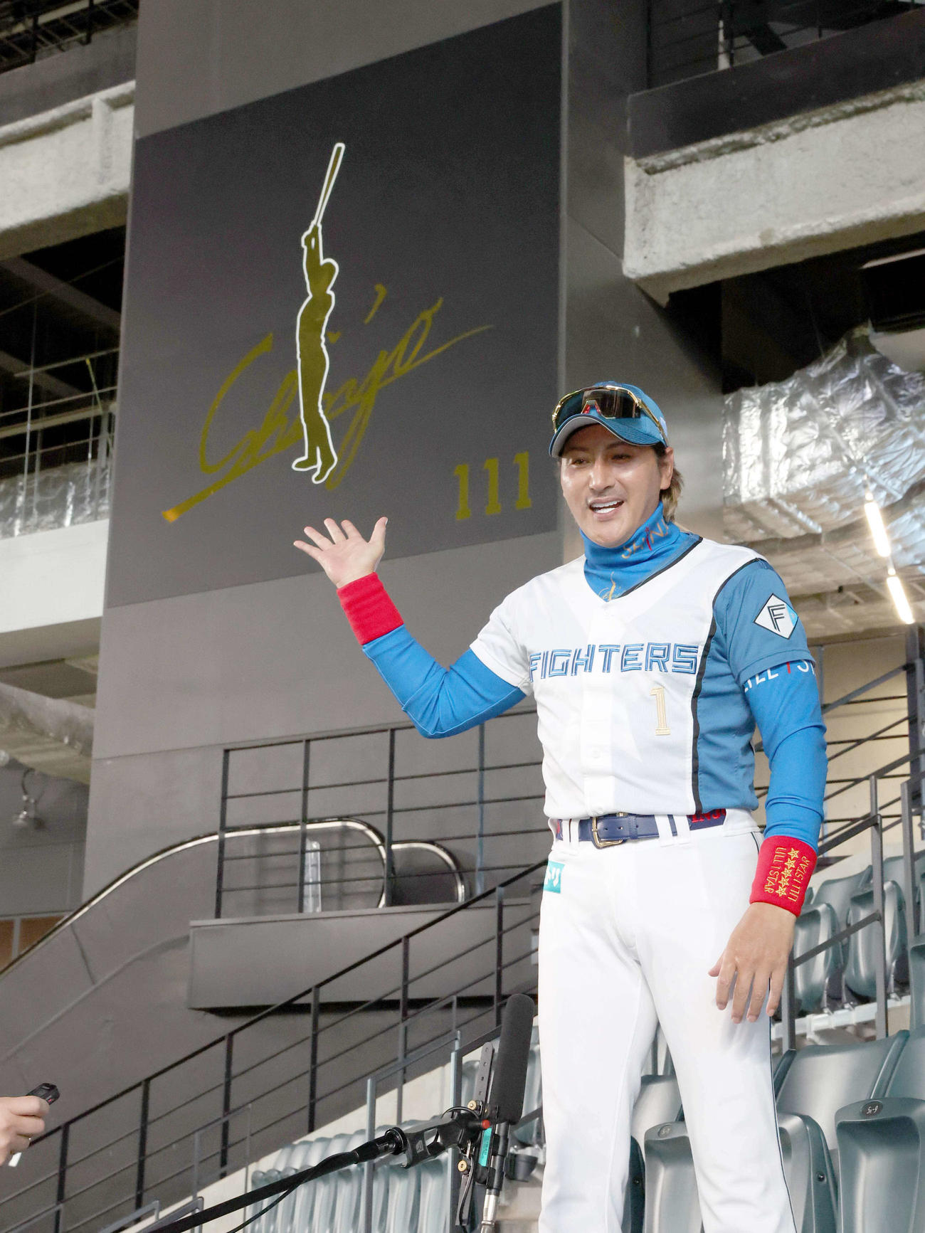 レフトスタンドに新たに設置された看板の前で話す日本ハム新庄監督（撮影・黒川智章）