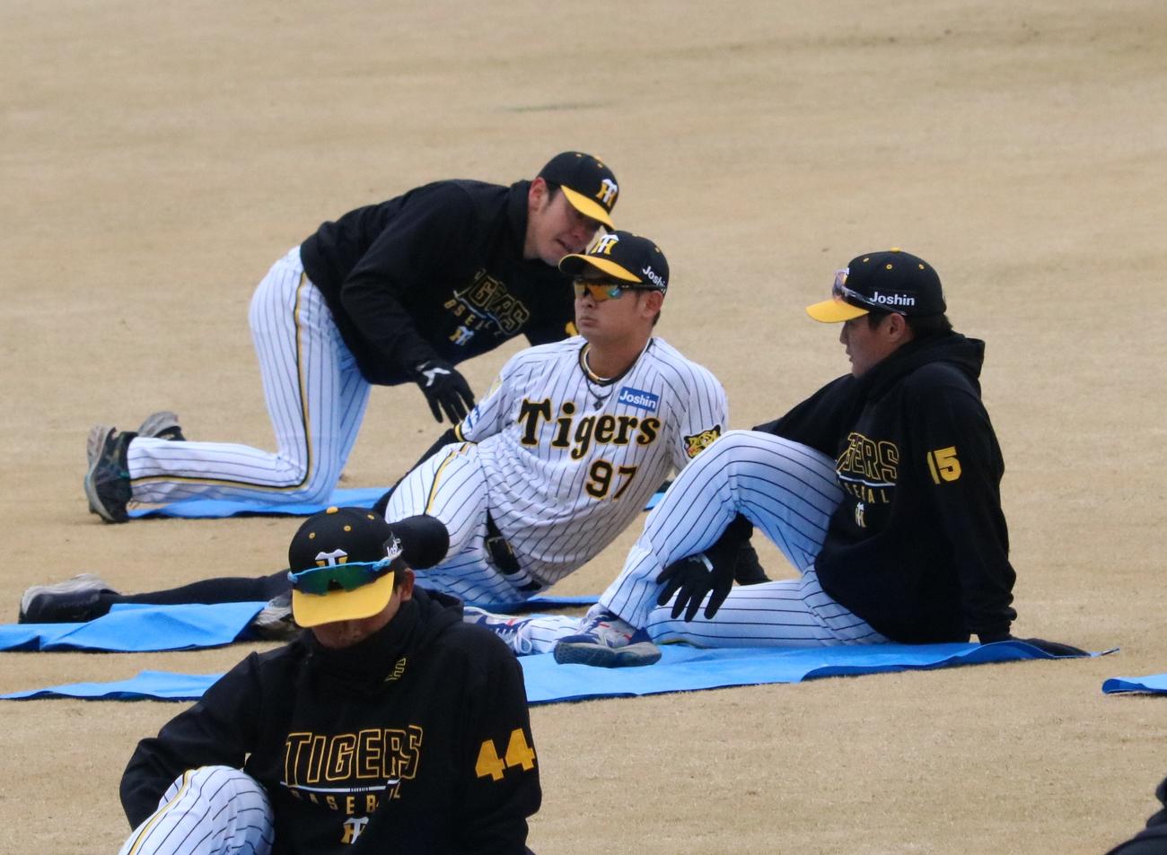 阪神の野口恭佑外野手と西純矢投手らがストレッチを行う（撮影・林亮佑）＝2024年2月29日、鳴尾浜球場