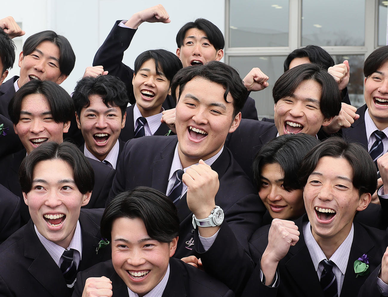 卒業式を終え、記念撮影に笑顔を見せる佐々木麟（中央）（撮影・足立雅史）