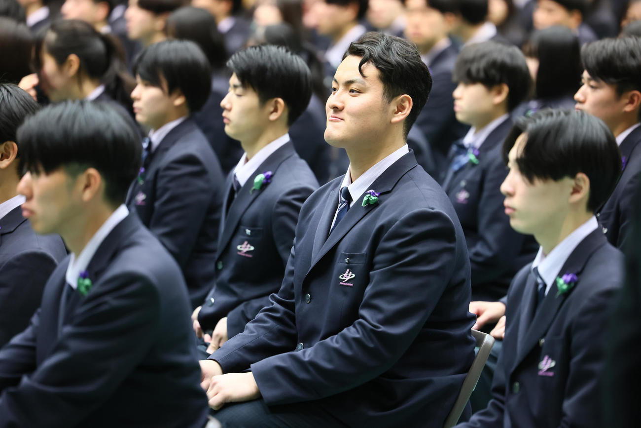卒業式で関係者の激励に笑顔を見せる佐々木麟（撮影・足立雅史）