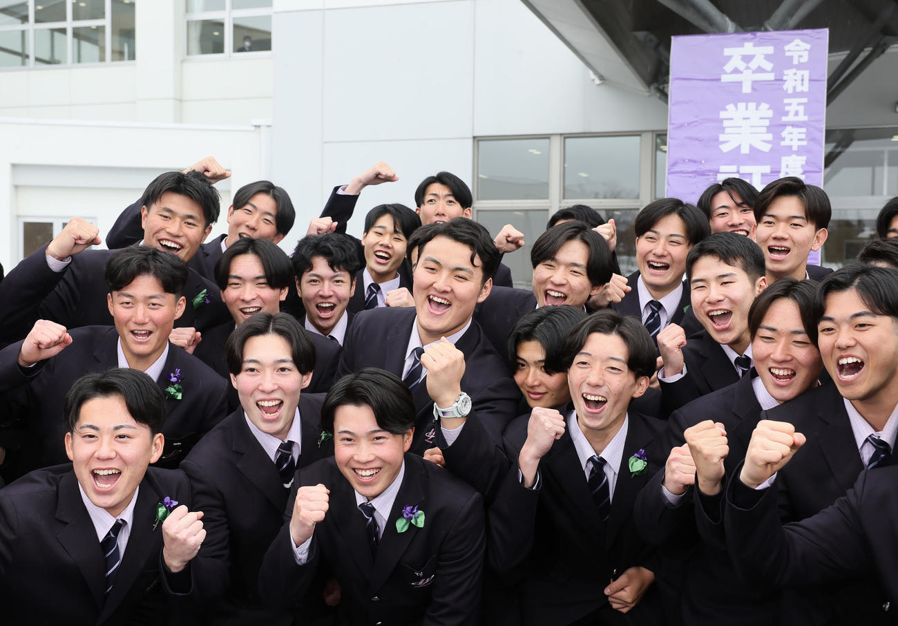 卒業式を終え、記念撮影に笑顔を見せる佐々木麟（中央）（撮影・足立雅史）