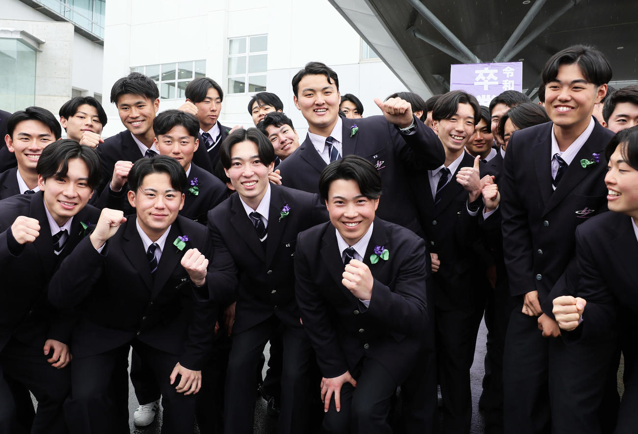 卒業式を終え、記念撮影に笑顔を見せる佐々木麟（後方中央）（撮影・足立雅史）