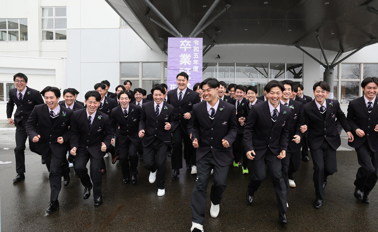 卒業式を終え、記念撮影で笑顔で駆け出す佐々木麟（中央）（撮影・足立雅史）