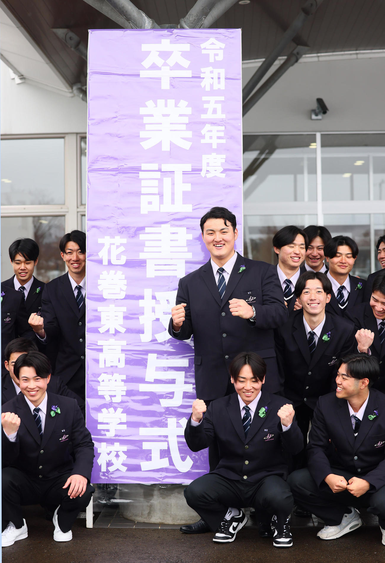 卒業式を終え、記念撮影に笑顔を見せる佐々木麟（中央）（撮影・足立雅史）