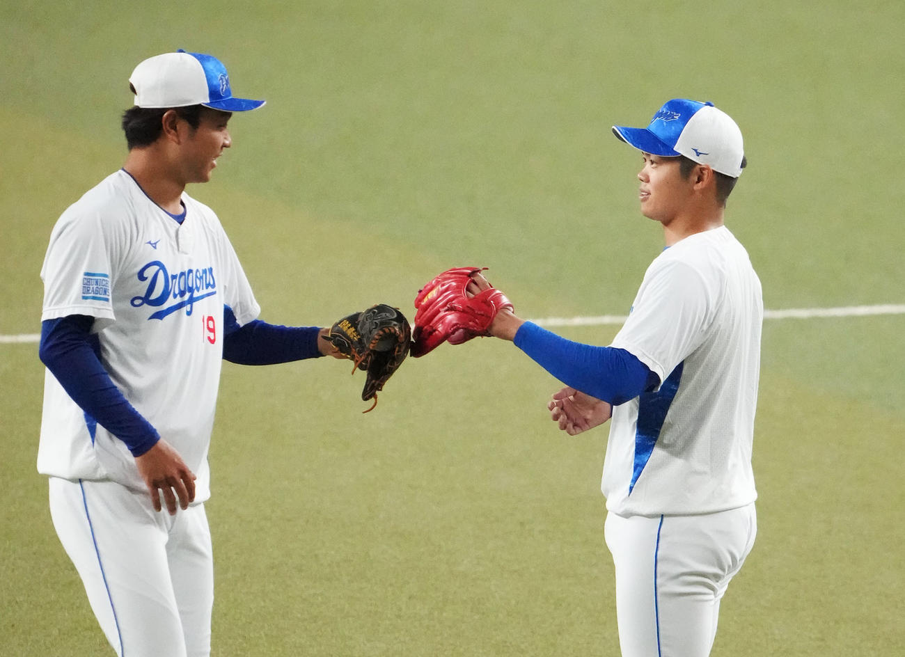 キャッチボールを終え高橋宏とタッチを交わす根尾（右）（撮影・森本幸一）
