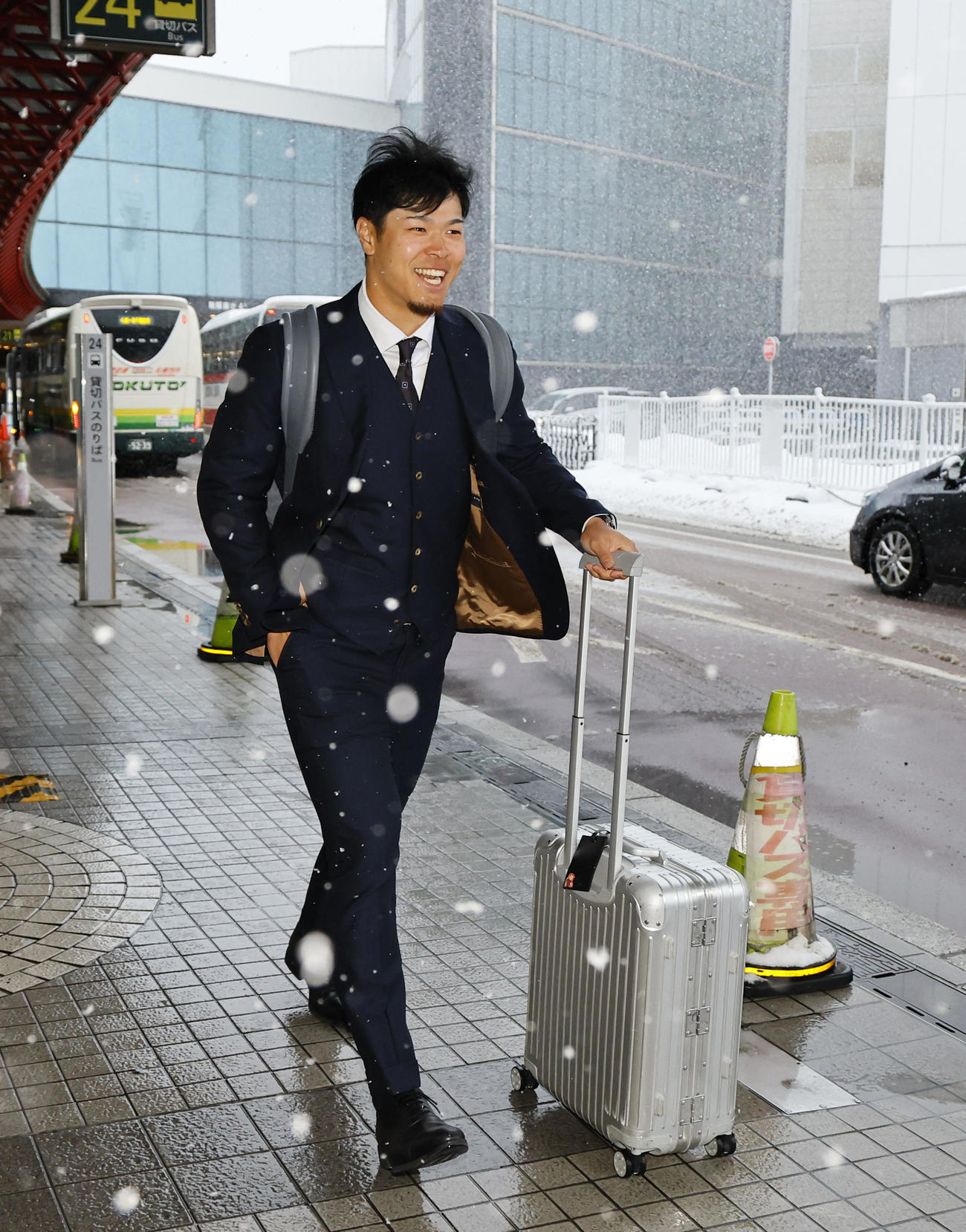 北海道に到着し、雪がふぶく中バスに向かう佐藤輝（撮影・藤尾明華）