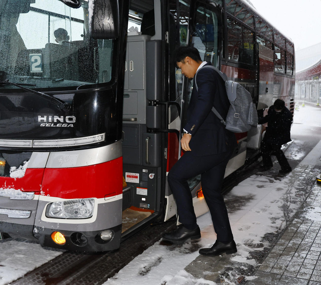 北海道に到着し、雪がふぶく中バスに乗り込む佐藤輝（撮影・藤尾明華）