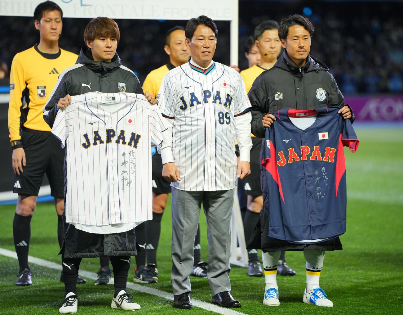 川崎F対磐田　試合前、始球式を務めユニホームを贈呈する侍ジャパン井端監督（中央）。左は川崎F脇坂、右は磐田山田（撮影・垰建太）