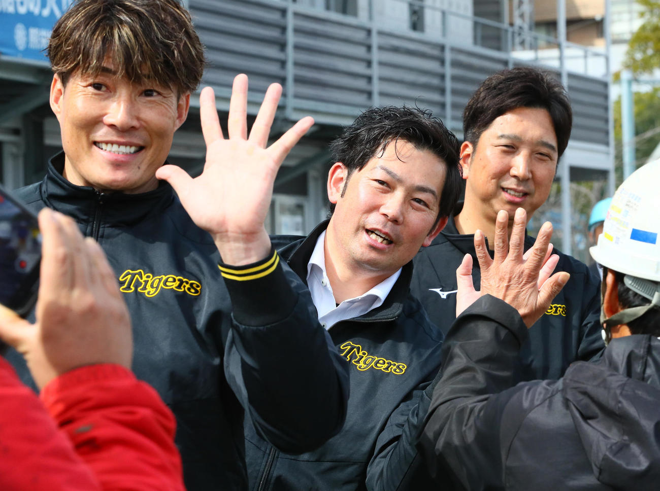 建設工事作業員をハイタッチで激励する、左から糸井SA、岩田CA、藤川球団本部付SA（撮影・上山淳一）