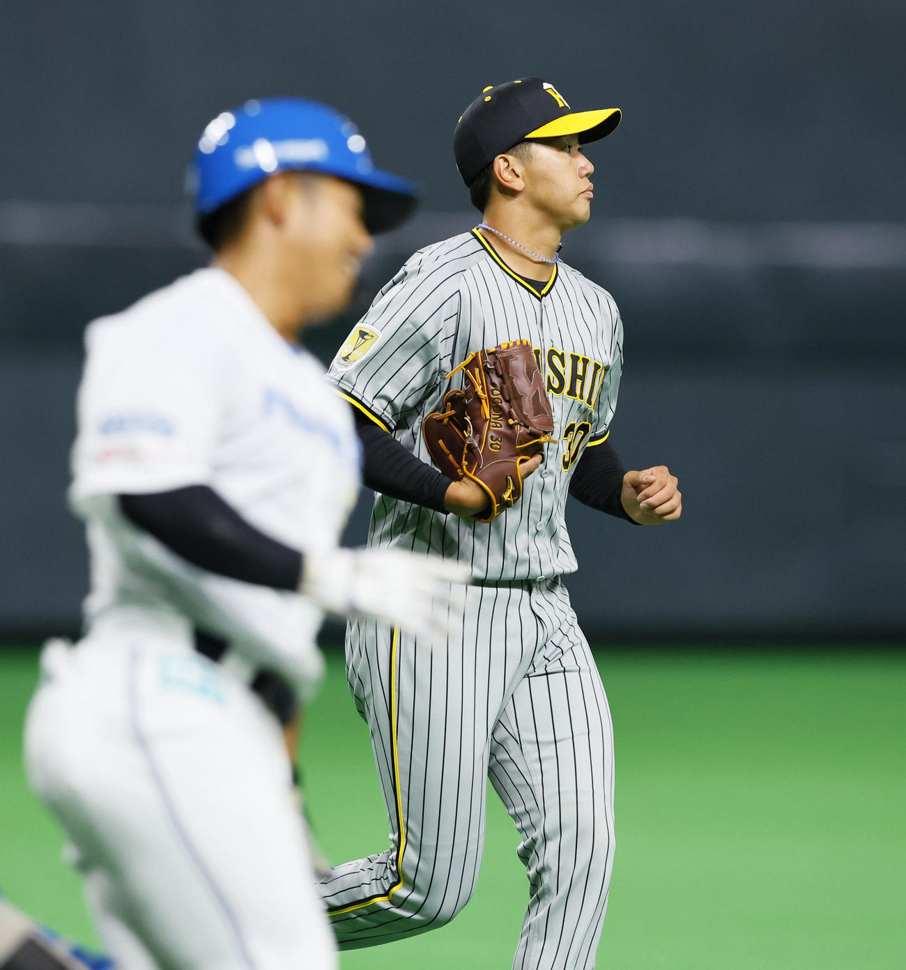 日本ハム対阪神　1回裏日本ハム1死、今川（左）を一飛に打ち取った阪神門別（撮影・藤尾明華）