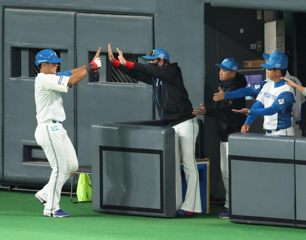 日本ハム対阪神　8回裏日本ハム2死一塁、ミエセスの後逸の間に生還した一走野村（左）を出迎える新庄監督（撮影・佐藤翔太）