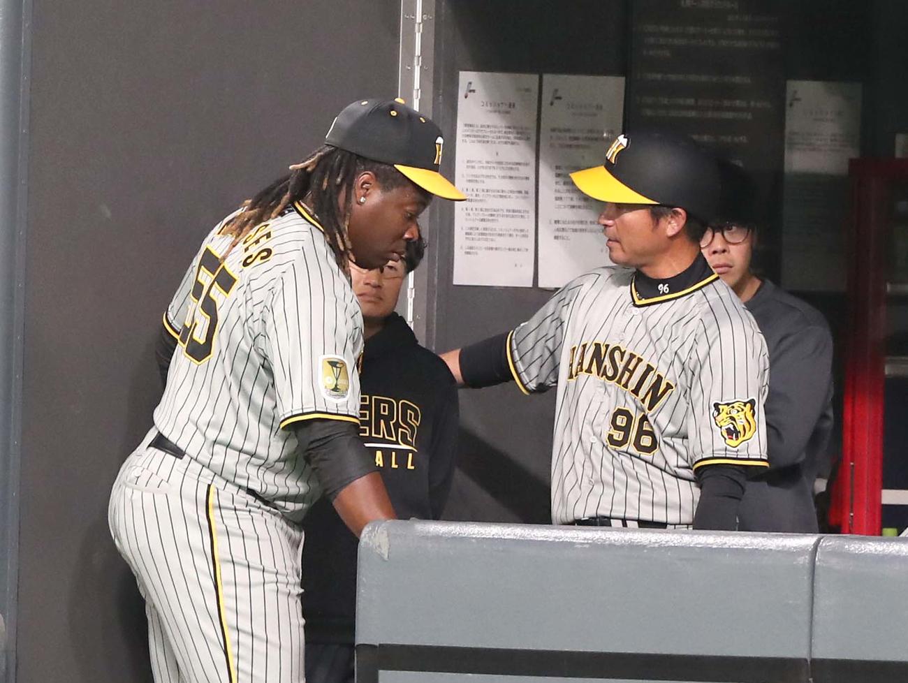 日本ハム対阪神　8回裏、打球を後逸したミエセスはベンチで筒井コーチに指導を受ける（撮影・黒川智章）