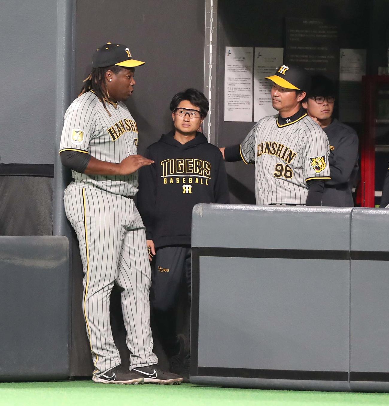 日本ハム対阪神　8回裏、打球を後逸したミエセスはベンチで筒井コーチに指導を受ける（撮影・黒川智章）