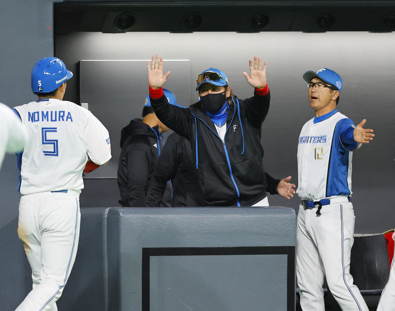 日本ハム対阪神　8回裏日本ハム2死一塁、浅間の左前打で相手守備が乱れる間に生還した野村を出迎える新庄監督（中央）（撮影・藤尾明華）