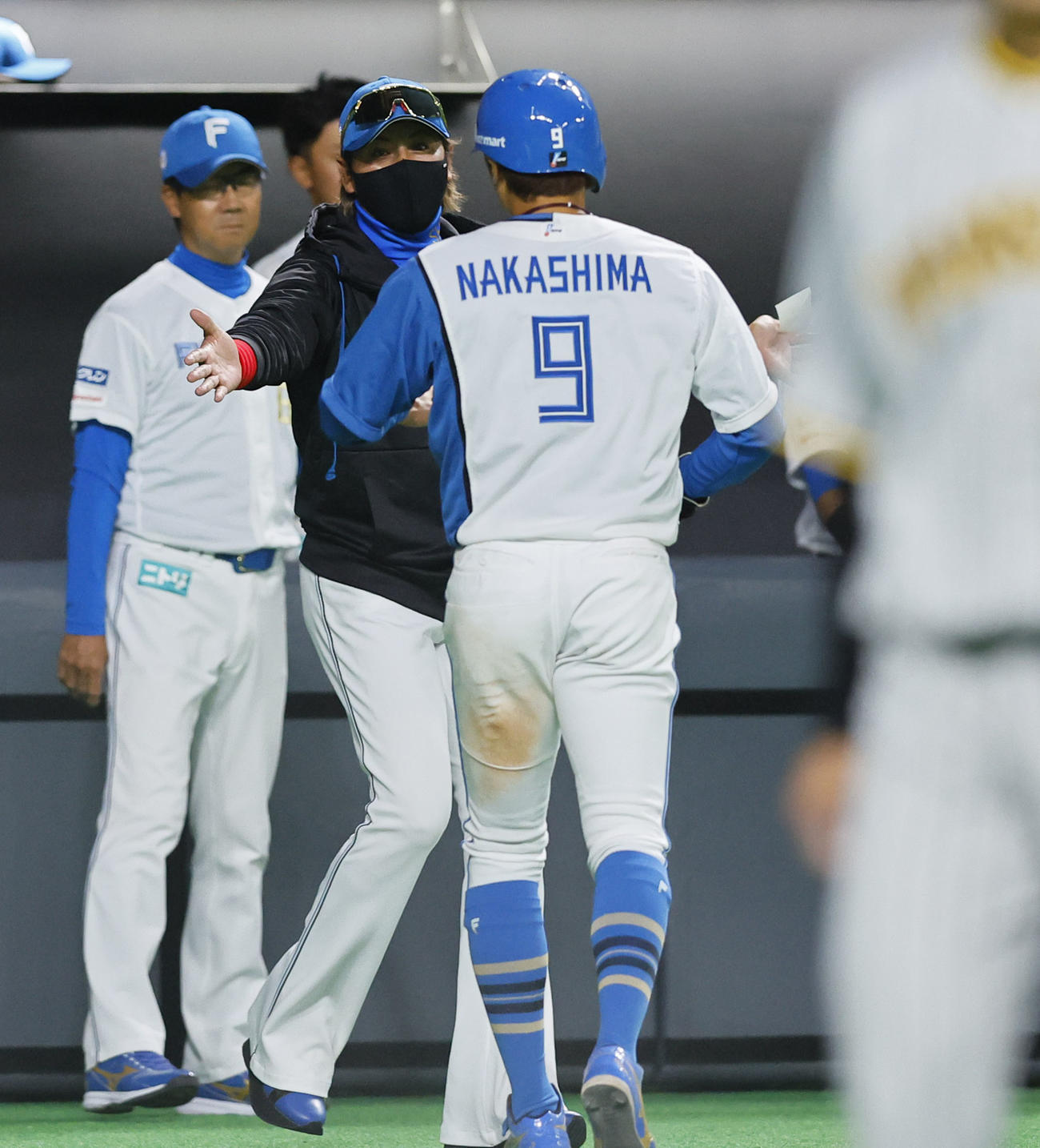 日本ハム対阪神　5回裏日本ハム2死二塁、細川の右前適時打で生還した中島を出迎える新庄監督（撮影・藤尾明華）