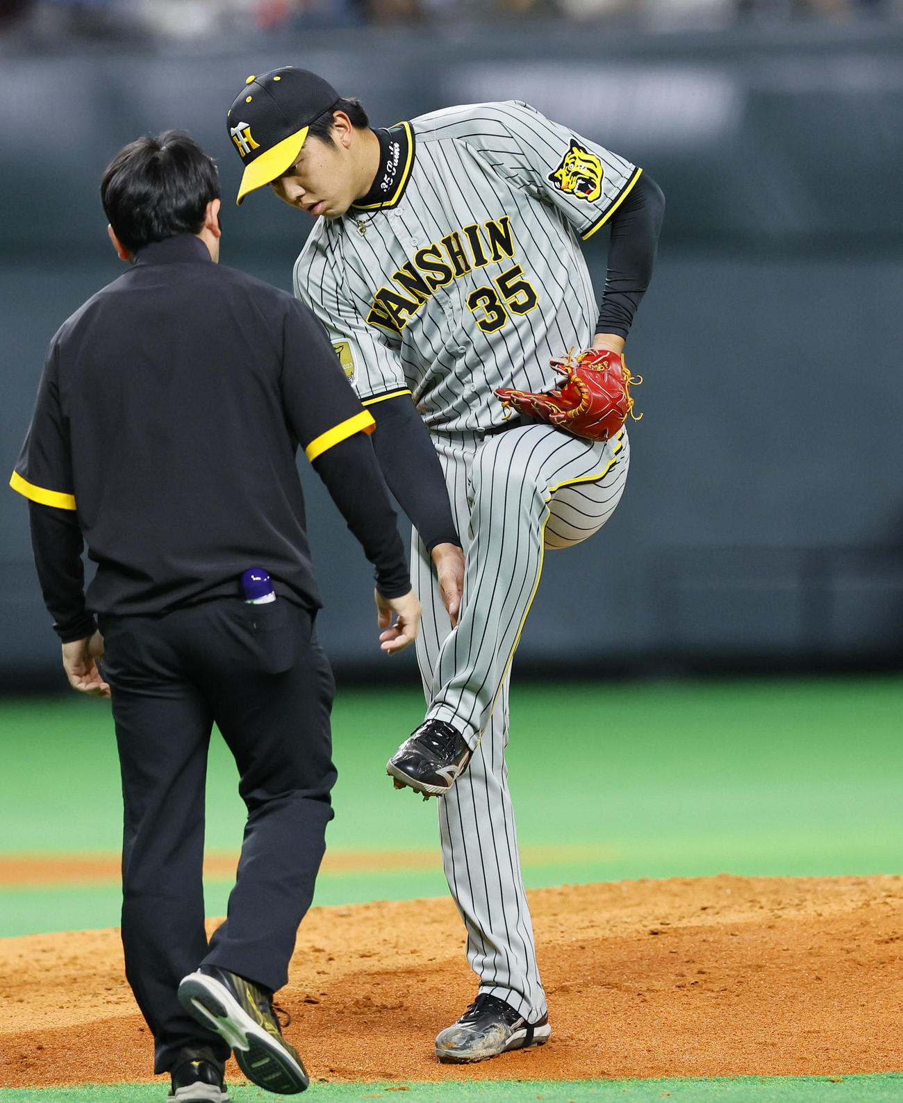 日本ハム対阪神　3回裏日本ハム2死、伏見の打球を左足に受けトレーナーに見せる阪神才木（撮影・藤尾明華）