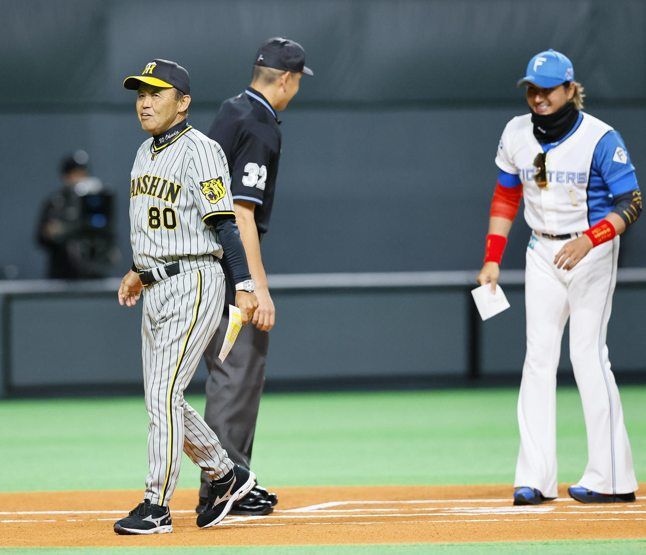 日本ハム対阪神　メンバー表交換で日本ハム新庄監督（右）と言葉を交わし笑顔を見せる阪神岡田監督（撮影・藤尾明華）