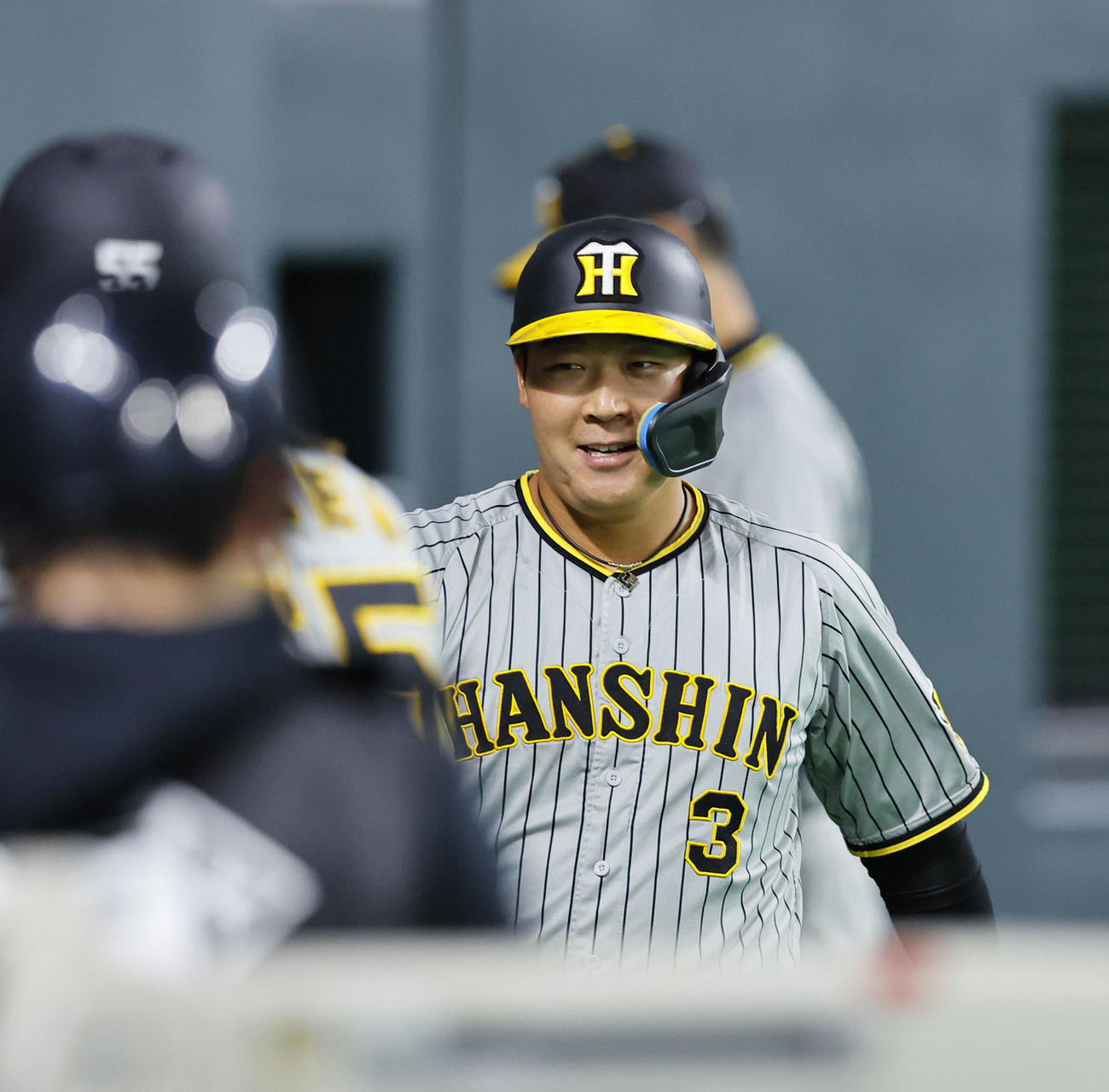 日本ハム対阪神　6回表阪神1死三塁、ミエセスの中犠飛で生還し、ベンチのナインとタッチを交わす大山（撮影・藤尾明華）