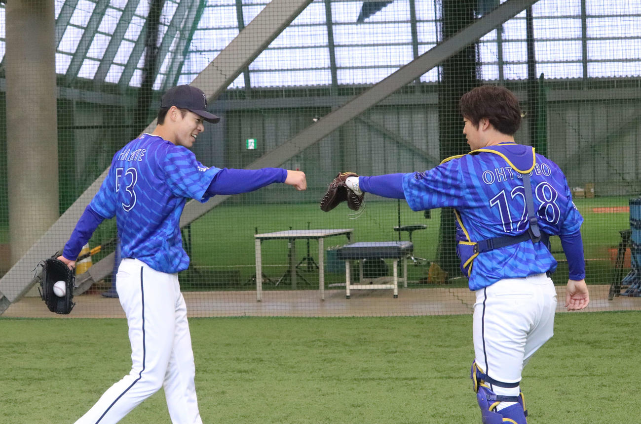ブルペン入りした中川颯（左）は投球を受けた桐光学園時代の同級生・大坪チームサポーターブルペン捕手兼ファーム用具担当とグータッチ（撮影・小早川宗一郎）