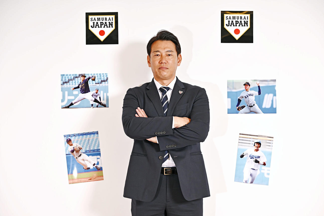 引き締まった表情でカメラを見つめる侍ジャパン井端監督。壁に貼られた写真は左下から時計回りに、明大・宗山、愛知工大・中村、関大・金丸、青学大・西川（撮影・滝沢徹郎）