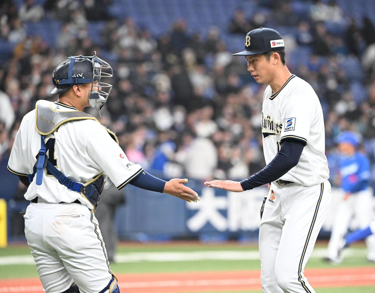 オリックス対中日　4回を投げ終え、、捕手森（左）とタッチする曽谷（撮影・和賀正仁）