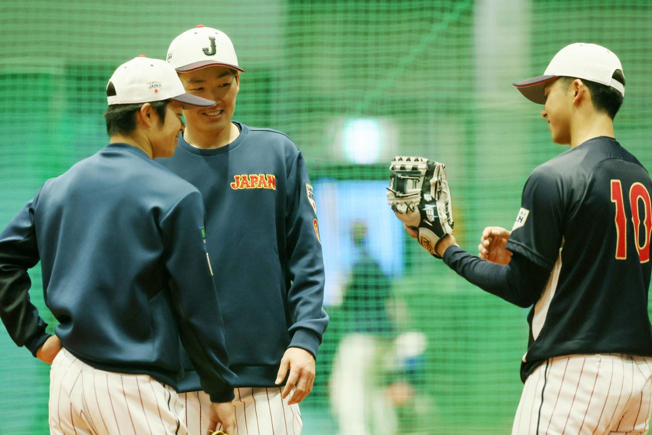 宗山（右）のグラブを見る源田。左は中野（撮影・加藤哉）