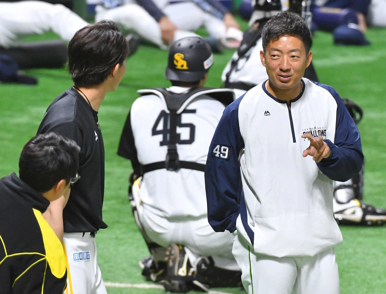 ソフトバンク対ヤクルト　試合前、ソフトバンク周東（左）にフォークを予告？するヤクルト嘉弥真（撮影・岩下翔太）