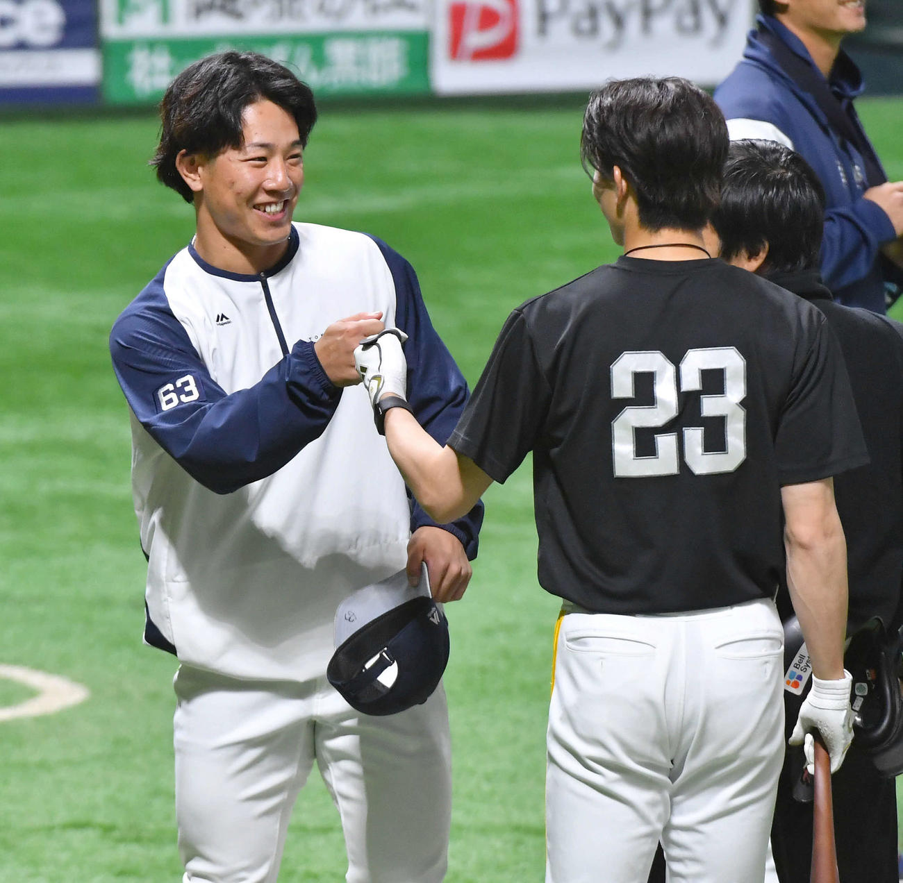 ソフトバンク対ヤクルト　試合前、ソフトバンク周東（右）と笑顔でグータッチを交わすヤクルト増田（撮影・岩下翔太）