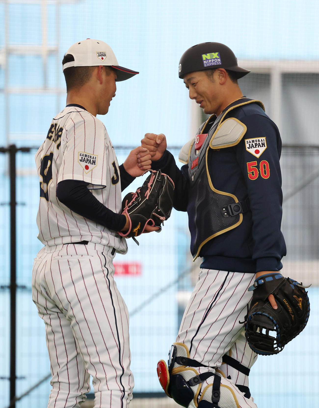 投球練習を終えグータッチを交わす金丸（左）と山本（撮影・前田充）